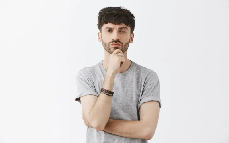 Homem olhando o próprio corpo com dúvida sobre a coloração do pênis